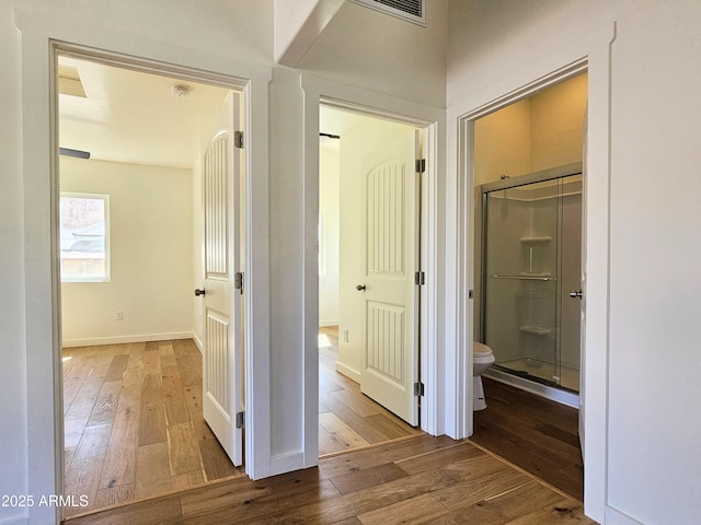 hall featuring hardwood / wood-style floors and baseboards