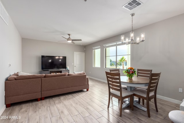 2511 W Queen Creek Rd Unit 205, Chandler, AZ 85248 - dining space featuring a chandelier, a ceiling fan, baseboards, and light wood-type flooring