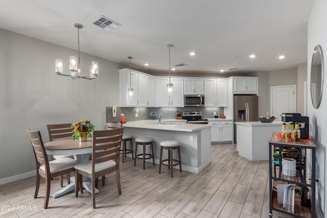 2511 W Queen Creek Rd Unit 205, Chandler, AZ 85248 - kitchen featuring appliances with stainless steel finishes, a peninsula, a sink, light countertops, and tasteful backsplash
