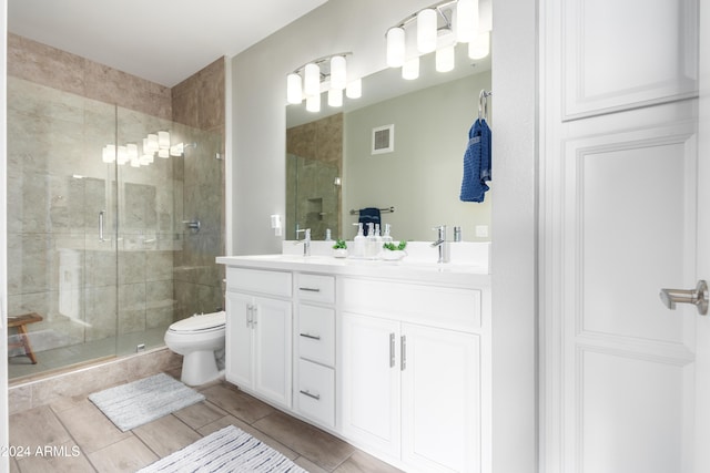 bathroom with tile patterned floors, vanity, toilet, and an enclosed shower