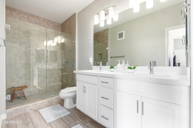 bathroom with walk in shower, vanity, and toilet