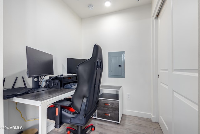 office space with electric panel, baseboards, and wood finished floors