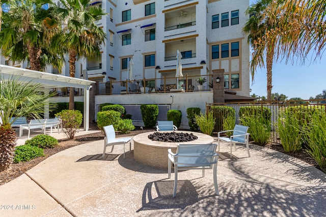 view of patio / terrace with a fire pit and a balcony