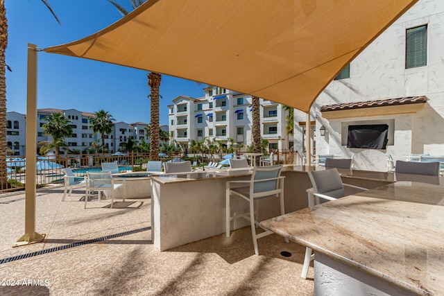 view of patio / terrace with exterior bar and a community pool