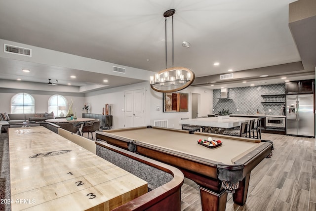 game room featuring billiards, light hardwood / wood-style flooring, a tray ceiling, and ceiling fan with notable chandelier