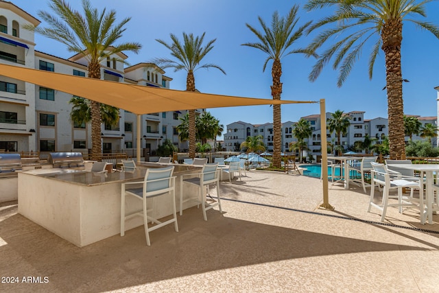 view of patio / terrace featuring an outdoor kitchen and a community pool