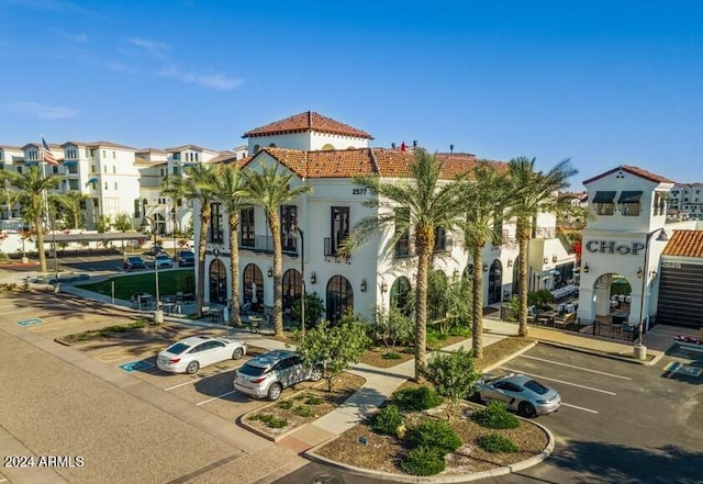 view of building exterior featuring uncovered parking and a residential view