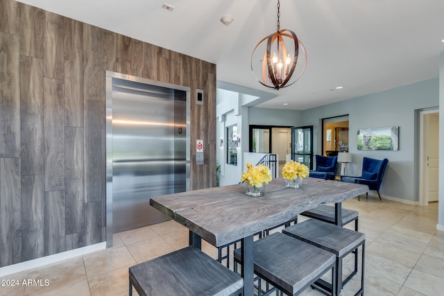 dining space with elevator, light tile patterned floors, baseboards, and an inviting chandelier