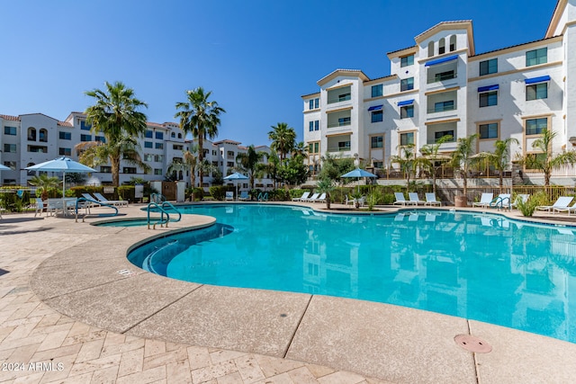 community pool with a residential view, fence, and a patio