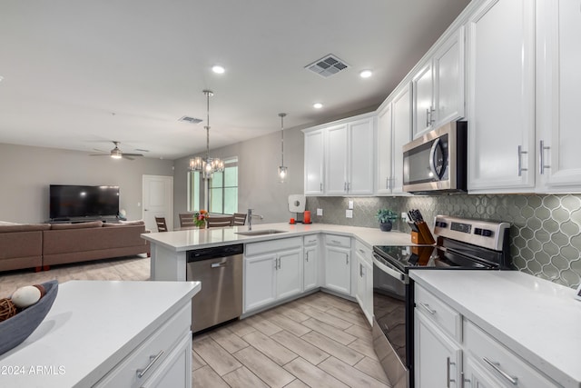 kitchen featuring pendant lighting, appliances with stainless steel finishes, and white cabinetry