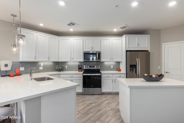 kitchen featuring stainless steel appliances, a sink, white cabinetry, visible vents, and decorative backsplash