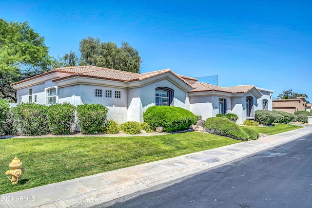 mediterranean / spanish house featuring a front lawn