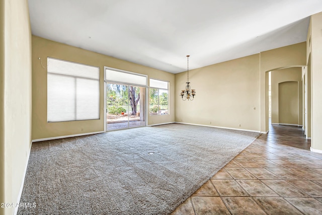 unfurnished room featuring a notable chandelier and light tile patterned floors