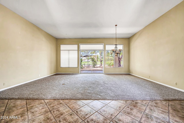 empty room with carpet and a chandelier