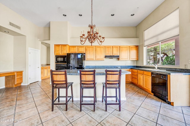 kitchen featuring a center island, black appliances, and a high ceiling