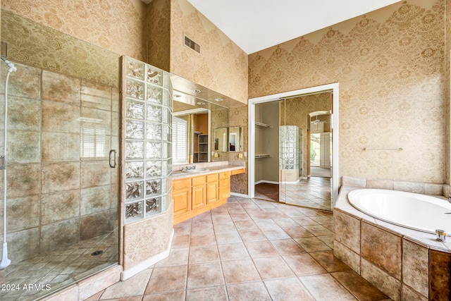 bathroom with tile patterned floors, plenty of natural light, independent shower and bath, and vanity