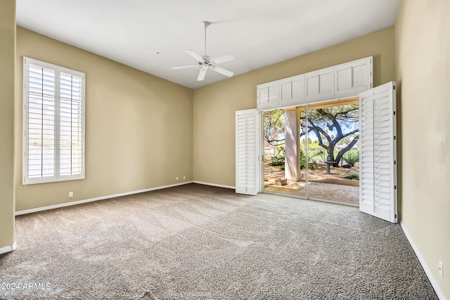 carpeted empty room featuring ceiling fan and a healthy amount of sunlight