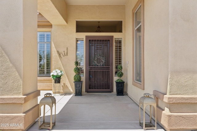 doorway to property featuring stucco siding