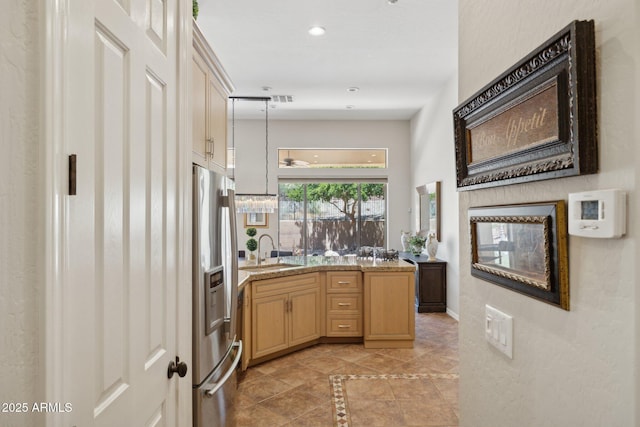kitchen featuring a sink, stainless steel fridge, inlaid floor details, recessed lighting, and a peninsula