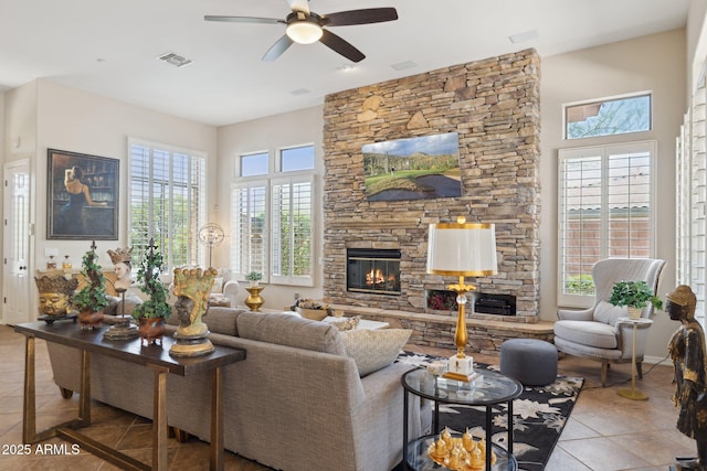 living area with tile patterned floors, a fireplace, ceiling fan, and plenty of natural light