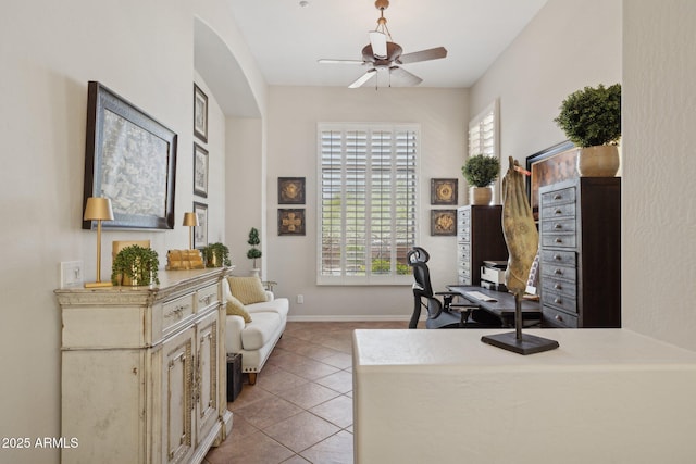 office featuring a ceiling fan, light tile patterned flooring, and baseboards