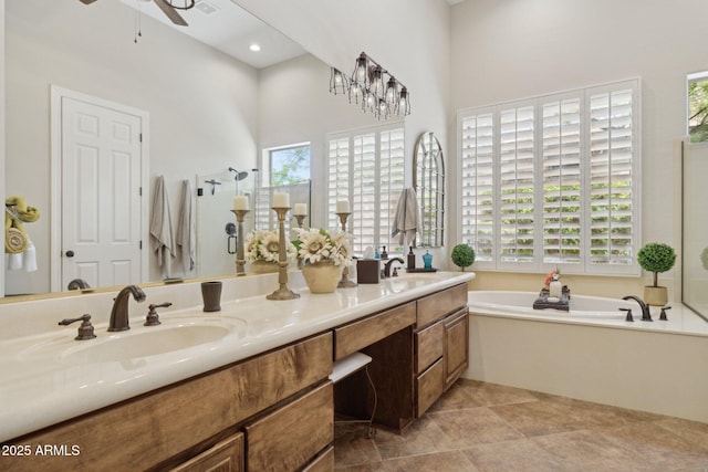 bathroom featuring ceiling fan, healthy amount of natural light, a garden tub, a shower stall, and a towering ceiling
