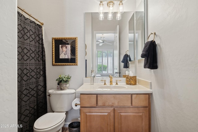 bathroom with toilet, vanity, a textured wall, ceiling fan, and curtained shower