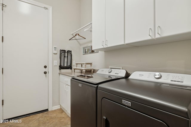 laundry room with washer and dryer, cabinet space, baseboards, and light tile patterned flooring