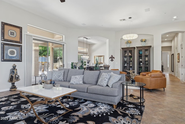 living area featuring arched walkways, recessed lighting, and baseboards