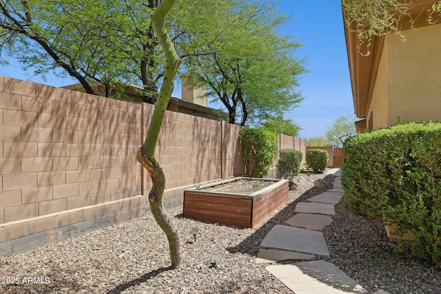 fenced backyard with a vegetable garden