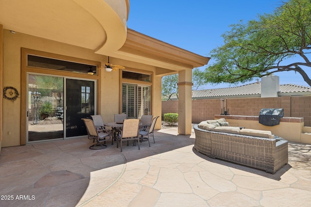 view of patio featuring fence, an outdoor hangout area, outdoor dining area, and a ceiling fan