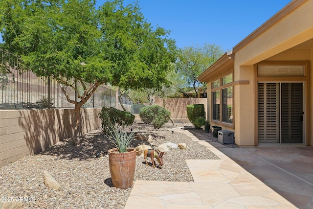 fenced backyard with a patio area and central AC unit