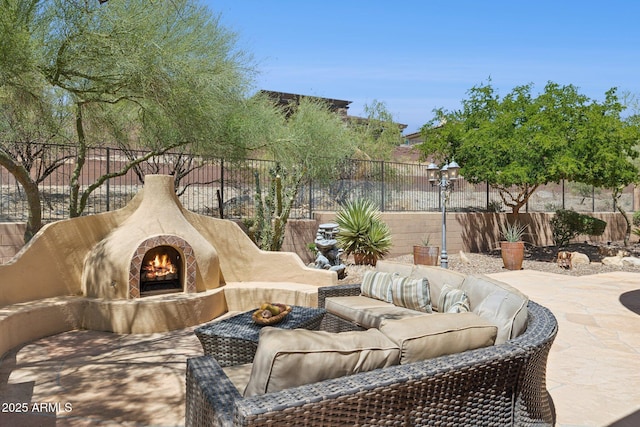 view of patio / terrace with an outdoor living space with a fireplace and fence