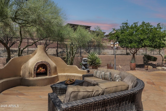 view of patio / terrace featuring an outdoor living space with a fireplace and fence