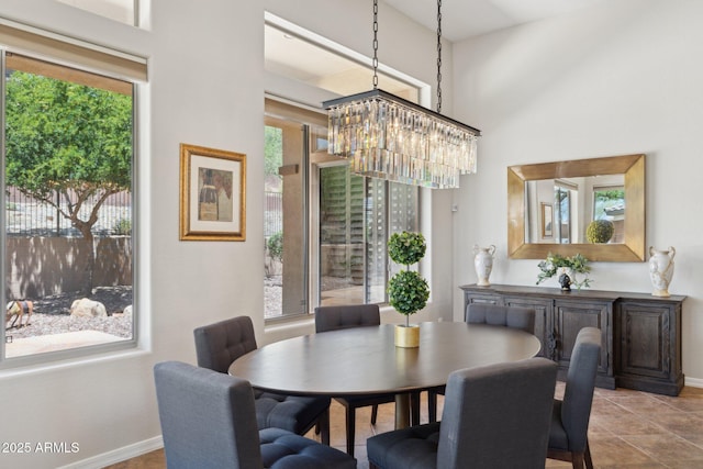 dining space with a chandelier, healthy amount of natural light, and baseboards