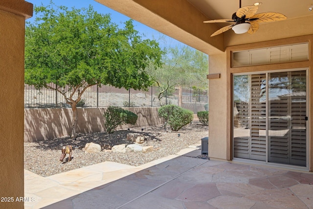 view of patio featuring a ceiling fan and fence