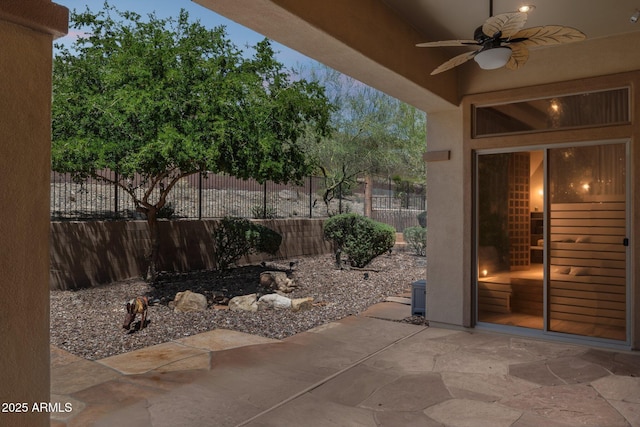 view of patio featuring ceiling fan and fence