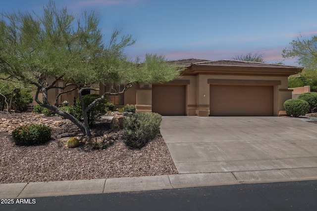 view of front of property featuring a garage, stucco siding, driveway, and a tile roof