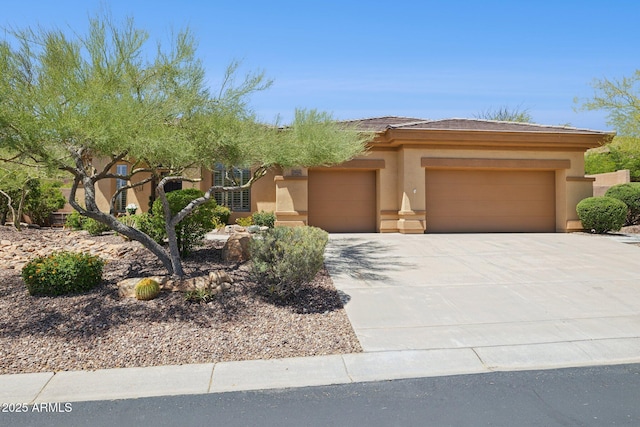 view of front of home with an attached garage, stucco siding, concrete driveway, and a tiled roof