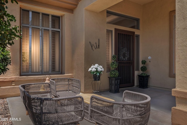 doorway to property featuring a patio area and stucco siding