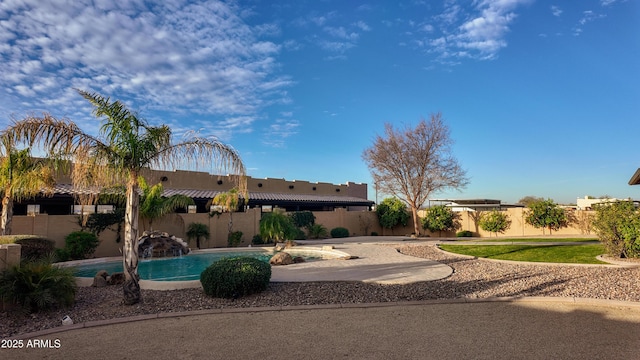 exterior space with a patio area, a fenced backyard, an outdoor pool, and stucco siding