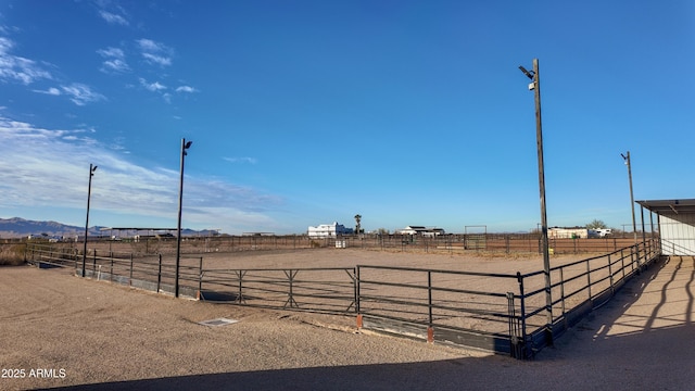 view of yard with fence, an enclosed area, and a rural view