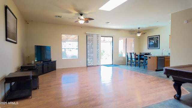 living area featuring a healthy amount of sunlight, light wood-style floors, and visible vents