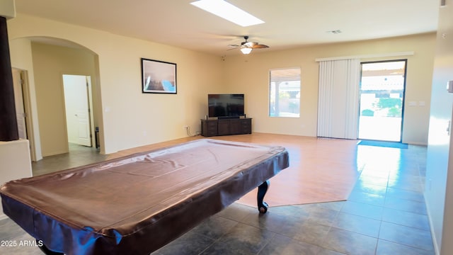 recreation room featuring a skylight, tile patterned flooring, arched walkways, and pool table