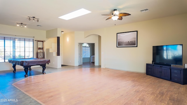 recreation room featuring arched walkways, visible vents, light wood-style floors, a ceiling fan, and baseboards