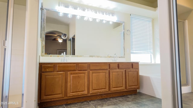 full bathroom featuring a sink, double vanity, a shower stall, and tile patterned floors