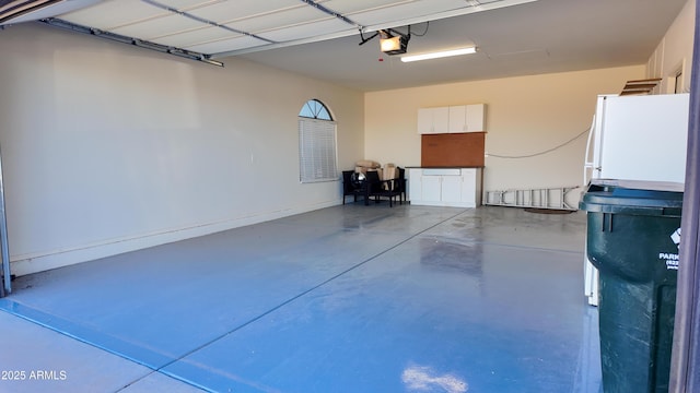 garage with freestanding refrigerator and a garage door opener