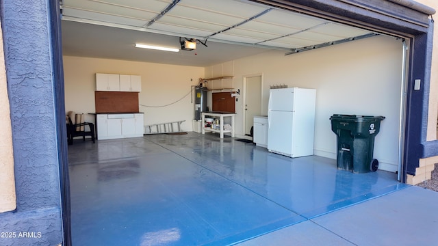 garage featuring water heater, freestanding refrigerator, and a garage door opener