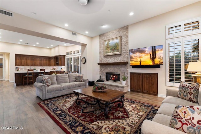 living room with a fireplace, hardwood / wood-style floors, and ceiling fan