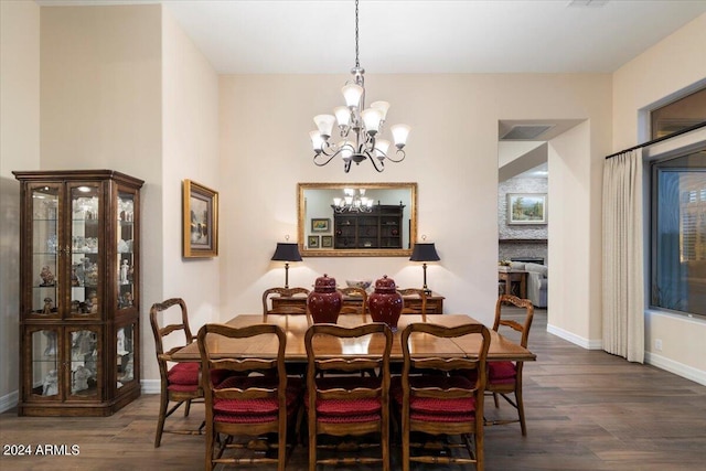 dining room with dark wood-type flooring and a chandelier